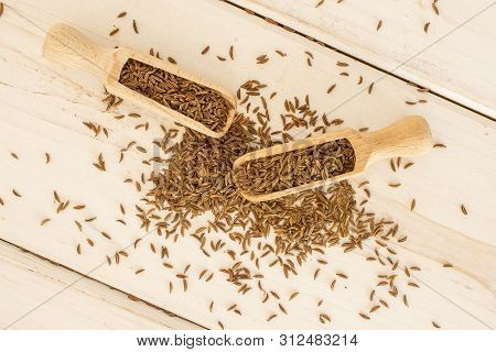 Lot Of Whole Dry Caraway Fruits With Two Wooden Scoops Flatlay On White Wood