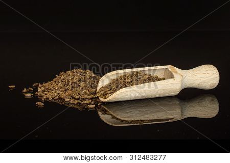 Lot Of Whole Dry Caraway Fruits Closeup With Wooden Scoop Isolated On Black Glass
