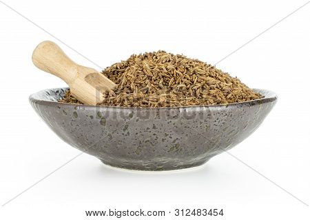 Lot Of Whole Dry Caraway Fruits In A Grey Ceramic Bowl With Wooden Scoop Isolated On White Backgroun