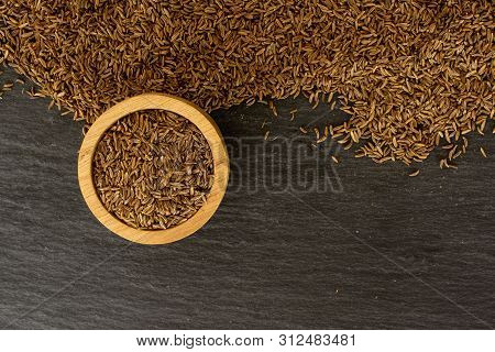 Lot Of Whole Dry Caraway Fruits Copyspace Below In A Wooden Bowl Flatlay On Grey Stone