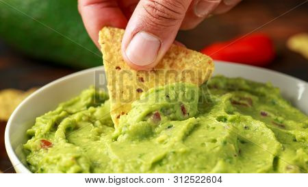 Man Hand Is Picking Some Guacamole Dip With Nachos Chip. Healthy Vegan, Vegetables Food.
