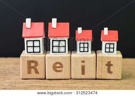 Reit, Real Estate Investment Trust Concept, Miniature Houses On Cube Wooden Block With Alphabet Comb
