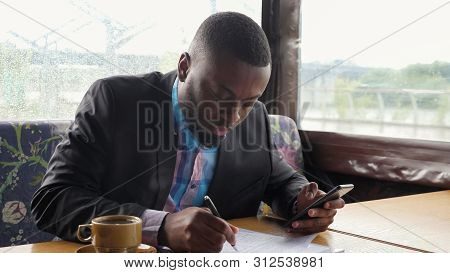 Black Guy Is Making Paperwork. Afro American Businessman Is Filling Documets In Summer Tent Cafe Loo