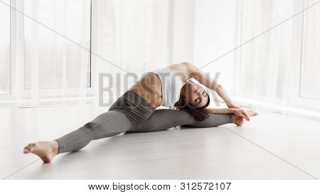 Contemp Dancer Stretching For Splits In Modern Ballet Studio. Panorama, Free Space For Text