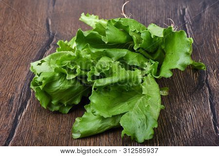 Lettuce Leaves On Wooden Table. Rustic Style.