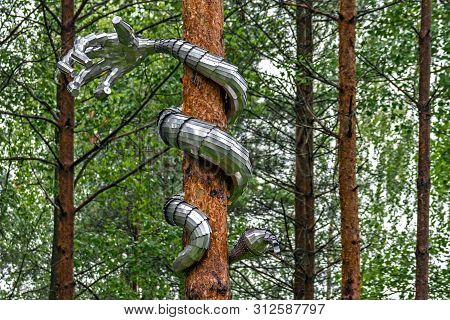 The Snake Is Made In The Form Of An Iron Hand, Twining The Trunk Of A Pine.