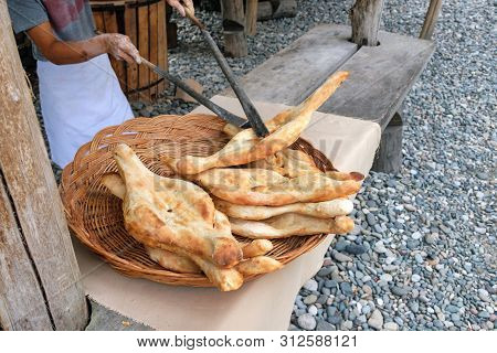 A Baker Is Stacking Traditional Georgian Flat Breads In The Basket