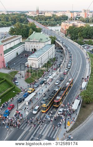 Warsaw, Poland - June 22 2019: Queues Of Cars Form As More Than A Hundred People Exit Trams And Cros