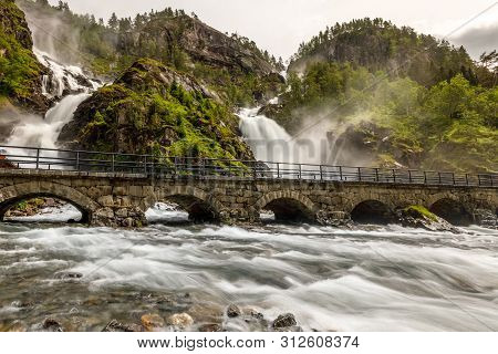 Latefoss Twin Waterfalls Streams Under The Stone Bridge Archs, Odda, Hordaland County, Norway