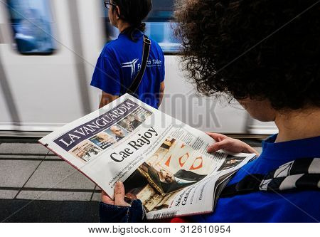 Barcelona - June 1 2018: Woman Reading In Barcelona Metro Station The La Vanguardia Newspaper Pedest