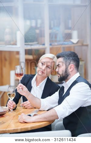 Professional cavists with wine samples examining their color