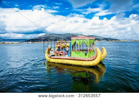 Uros, Peru - Jan 5, 2019. Traditional Totora boat with tourists on Titicaca lake near to the Uros floating islands , Puno, Peru, South America.