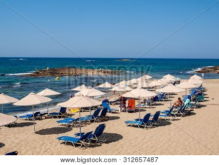 Malia, Crete, Greece - Juni 18, 2019: People Are Resting On A Sunny Day At The Beach In Malia, Crete