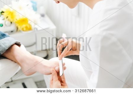 Podiatrist working on men's feet in her parlor