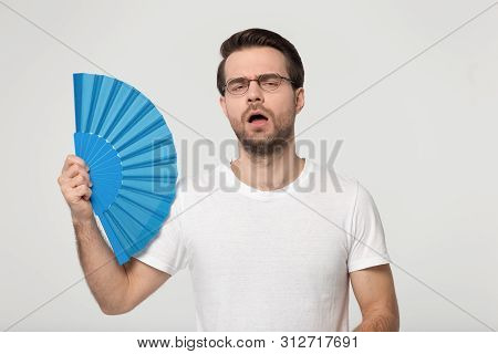 Millennial Guy Feeling Overheated Holds Waver Induces Airflow Cooling Himself