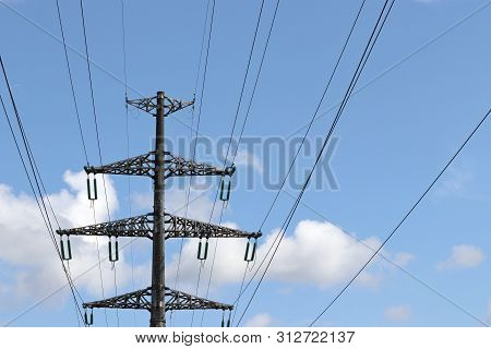 High Voltage Towers With Electrical Wires On Blue Sky And White Clouds Background. Electricity Trans