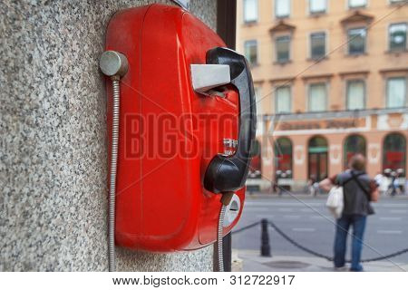 Red Metal Phone, Automatic, Payphone Hangs On The Wall On St. Petersburg City Street In Russia