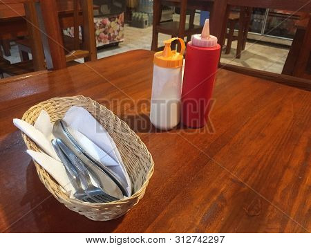 A Dinner Table In A Restaurant With Ketchup, Mayo And Cuttelry