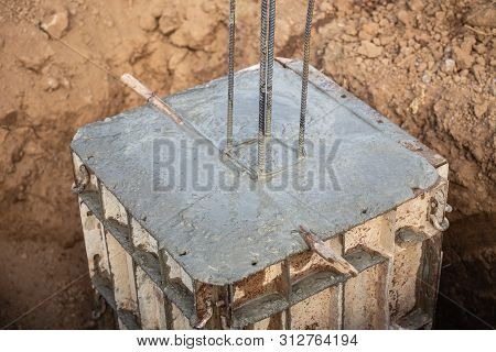 Pouring Concrete Into Steel Box For Foundation Pillar In Process Of House Building