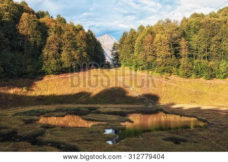 Autumn Caucasus Mountain Forest And Plant-filled Bolshoye Khmelevskoye Lake With Chugush Mountain Pe