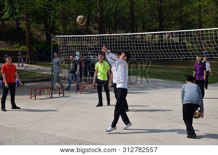 Pyongyang, North Korea - May 1, 2019: Amateurs Play Volleyball In A Public Park. Is An Amusement Par