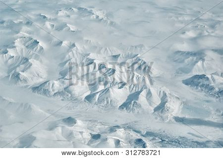 Snowy Mountain Ridges And River Valley Scenic Aerial Landscape On Sunny Winter Day.