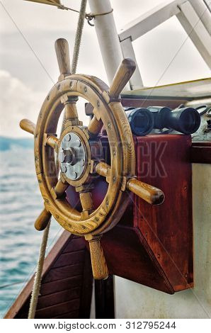Yacht Steering Wheel And Binoculars Vertical Close Up View On Sea Background
