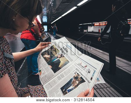 Barcelona - June 1 2018: Young Woman Reading In Barcelona Metro Station The La Vanguardia Newspaper 