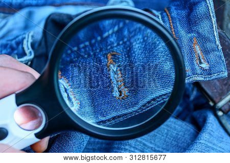 Black Magnifier Increases Blue Cotton Fabric With A Buttonhole On Clothes