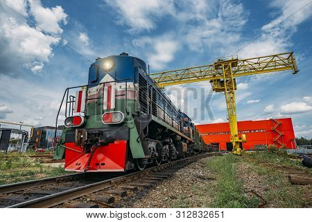 Freight Train With New Manufactured Pipes Exits From Warehouse.