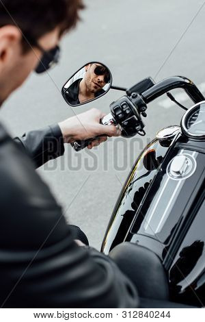 Selective Focus Of Reflection Of Handsome Young Man In Sungasses Sitting On Motorcycle