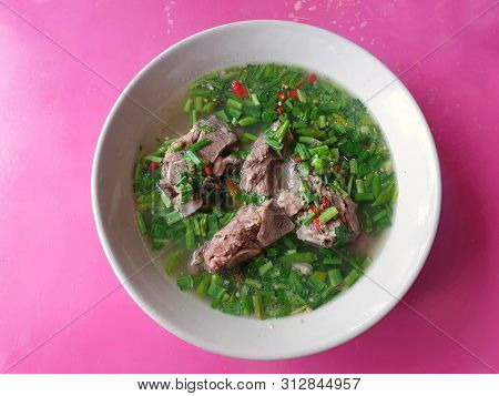 Thai Food Style, Top View Of Hot And Spicy Pork Neck Bones Soup In White Bowl Isolated On Pink Backg