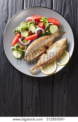 Fresh Fried Sarpa Salpa Fish With Summer Vegetable Salad  And Lemon Close-up On A Plate. Vertical To