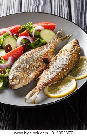 Fried Salema Porgy Sea Fish With Fresh Vegetable Salad Close-up On A Plate On The Table. Horizontal