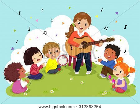 Young Woman Playing Guitar With A Group Of Kids Singing And Playing Musical Instruments. Female Teac
