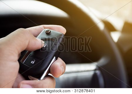 The Driver's Hand Is Pressed To The Remote Car Keyless.