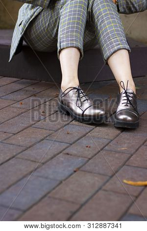 Close Up Woman Legs Weared Shortened Pants And Glossy Stylish Boots With Shoelaces On The Background
