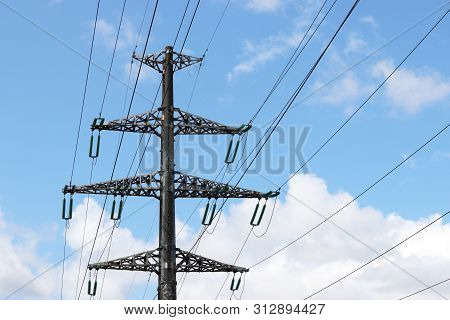 High Voltage Tower With Electrical Wires On Blue Sky And White Clouds Background. Electricity Transm