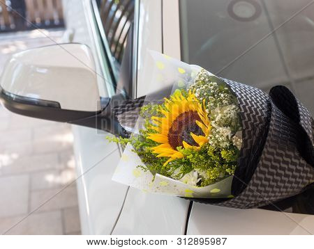 A Bouquet Of Sunflower On A White Car