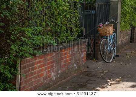 London - May 5, 2019 - A Bicycle Parked On The Sidewalk In Front Of Old Red Brick Lofts In The City 