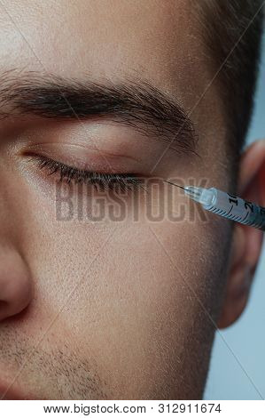 Close-up Portrait Of Young Man Isolated On Grey Studio Background. Filling Surgery Procedure. Concep