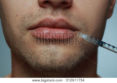 Close-up Portrait Of Young Man Isolated On Grey Studio Background. Filling Surgery Procedure. Concep
