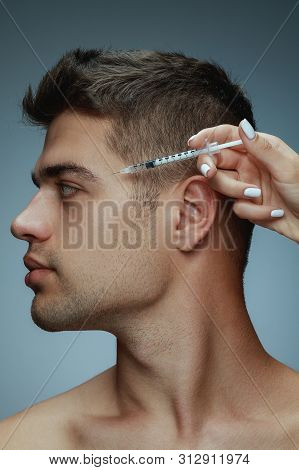 Close-up Profile Portrait Of Young Man Isolated On Grey Studio Background. Filling Surgery Procedure