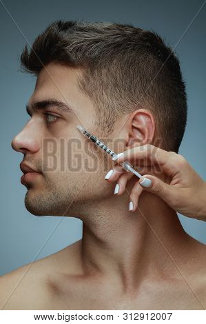 Close-up Profile Portrait Of Young Man Isolated On Grey Studio Background. Filling Surgery Procedure