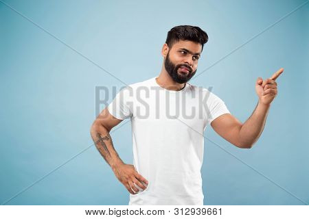Half-length Close Up Portrait Of Young Hindoo Man In White Shirt On Blue Background. Human Emotions,