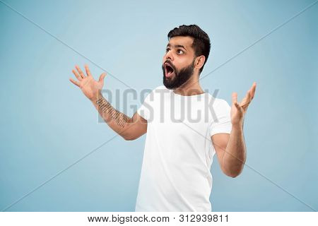 Half-length Close Up Portrait Of Young Hindoo Man In White Shirt On Blue Background. Human Emotions,