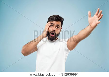 Half-length Close Up Portrait Of Young Hindoo Man In White Shirt On Blue Background. Human Emotions,