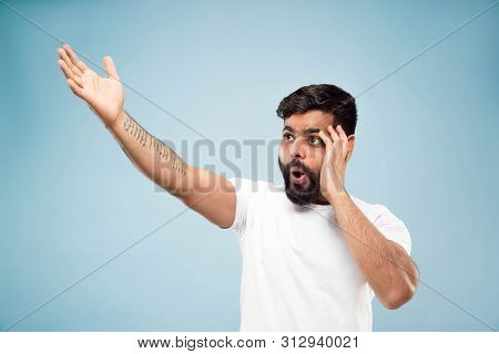 Half-length Close Up Portrait Of Young Hindoo Man In White Shirt On Blue Background. Human Emotions,