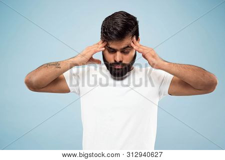 Half-length Close Up Portrait Of Young Hindoo Man In White Shirt On Blue Background. Human Emotions,