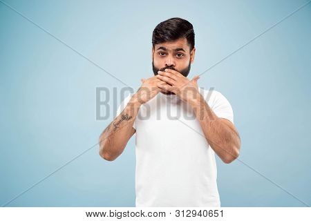 Half-length Close Up Portrait Of Young Hindoo Man In White Shirt On Blue Background. Human Emotions,